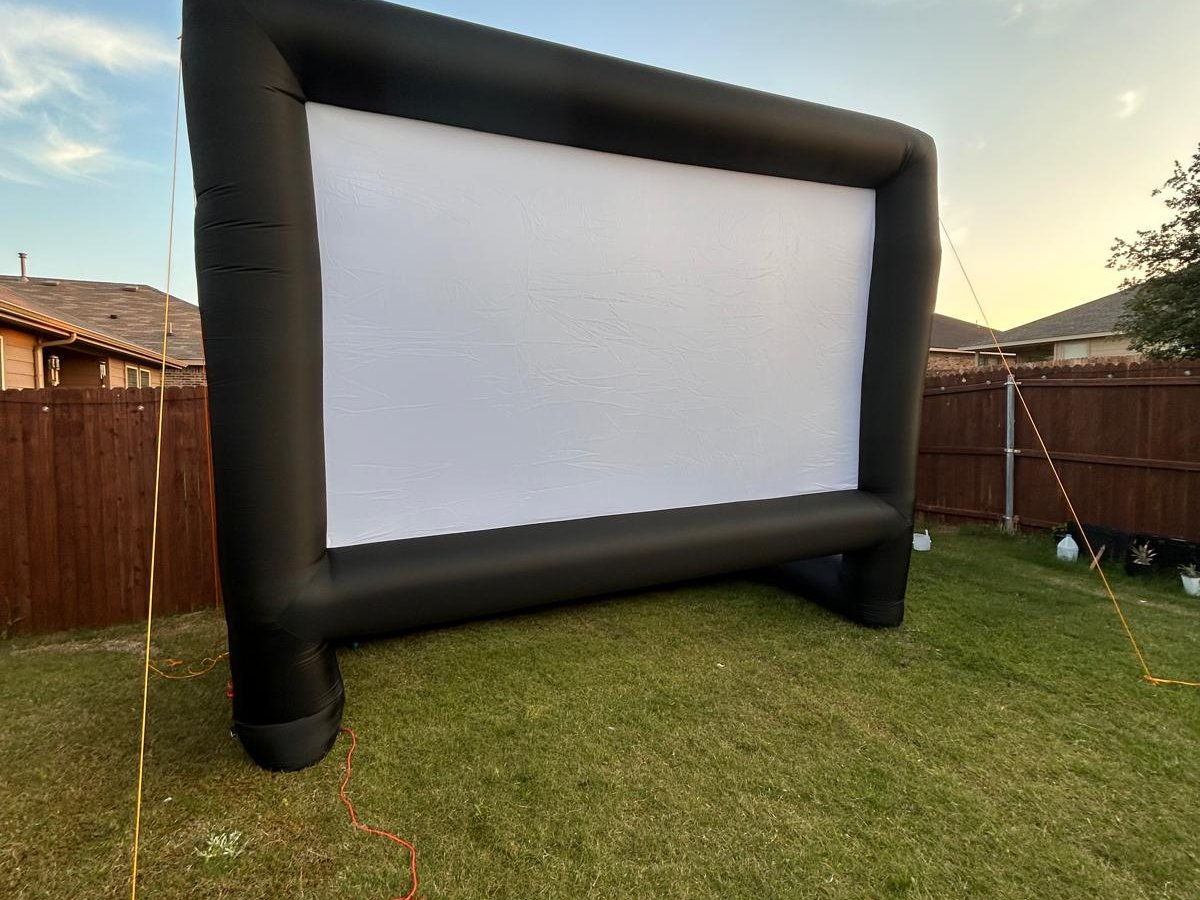 Outdoor movie screen at golden hour in a DFW backyard